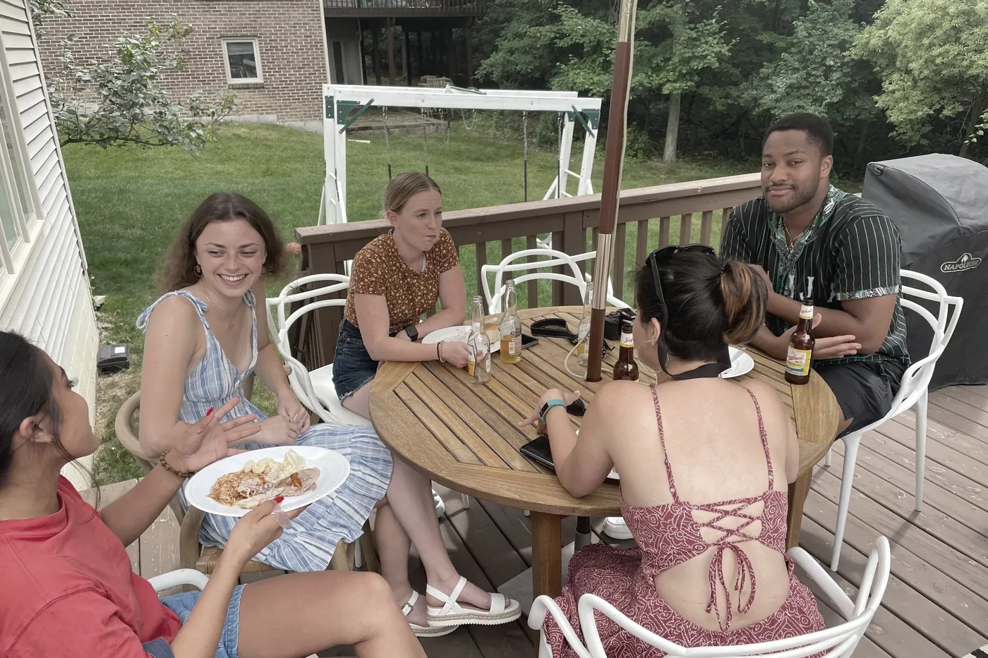 Lab members around a table on a back deck in summer