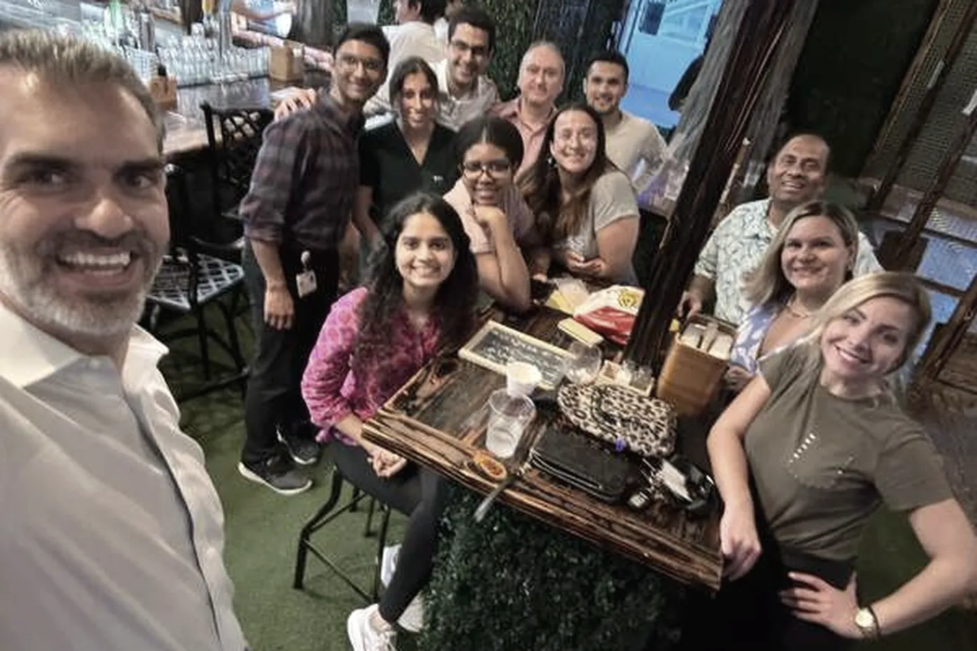 The team around an outdoor table celebrating a colleague's birthday