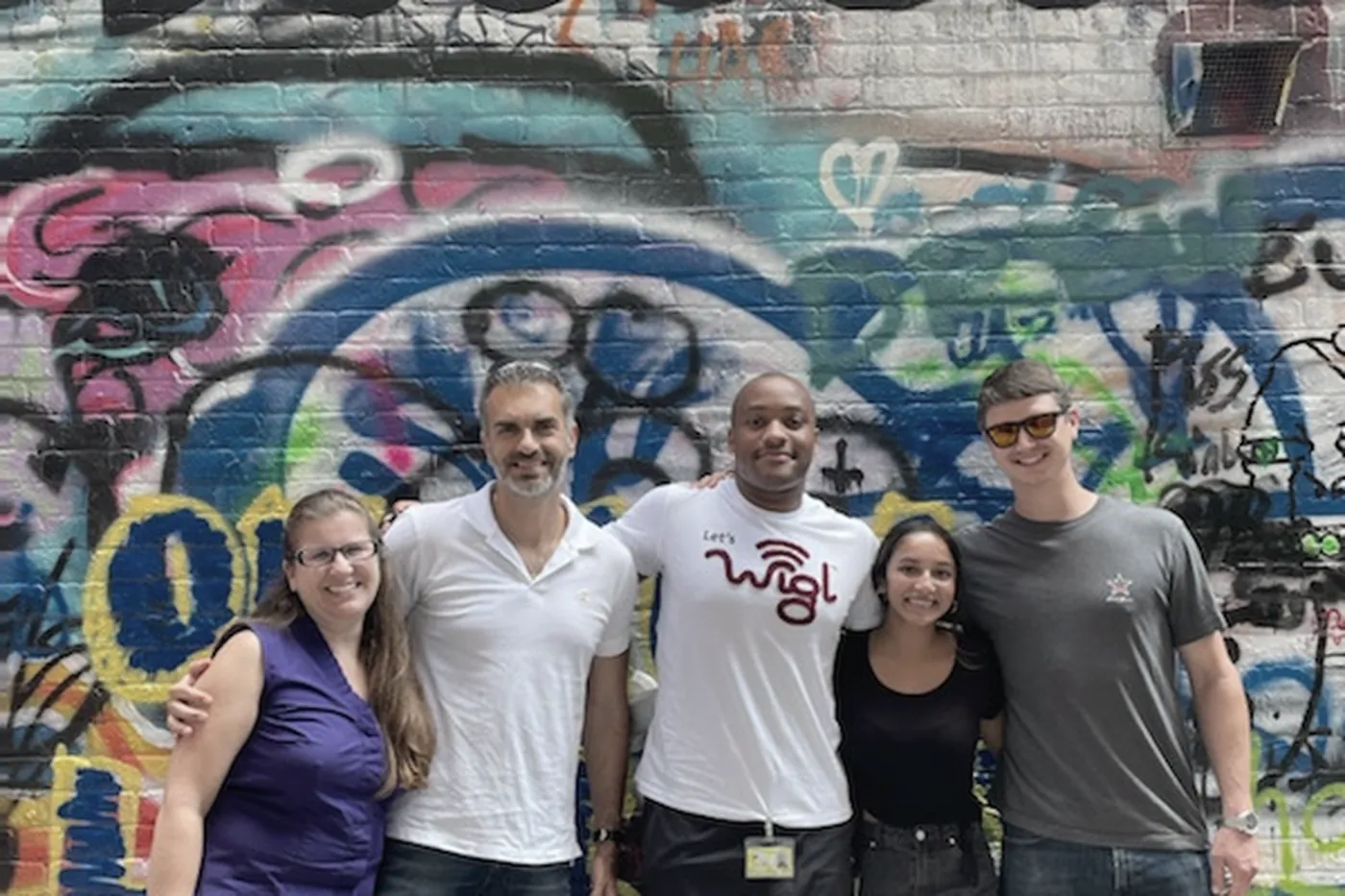 Lab members in front of a painted mural wall