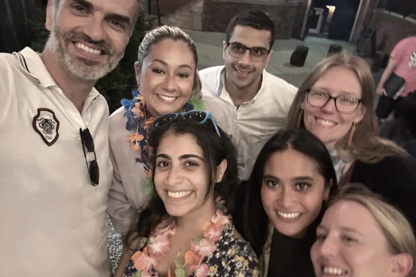 Lab members in flower leis at an evening summer party